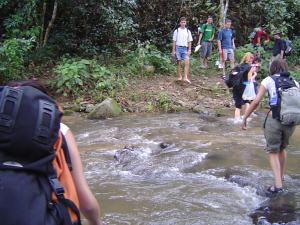 Tour group crossing a stream in the mountains of